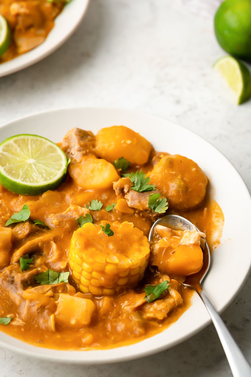 ajiaco cubano served in a white bowl with a silver spoon