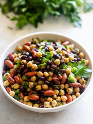 A plate with three bean salad tossed in chimichurri sauce