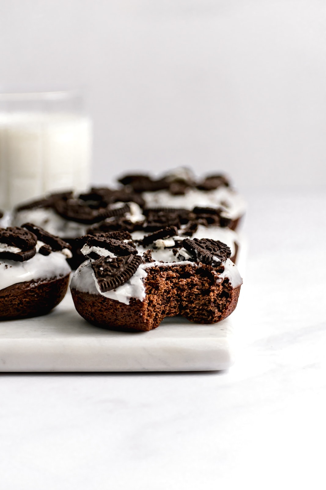 cookies and cream chocolate oreo donuts on a marble slab with milk