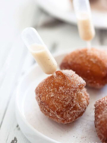 Quick and easy-to-make donut holes made in just minutes using refrigerated biscuit dough with a pipette of homemade coquito aka Puerto Rican eggnog!