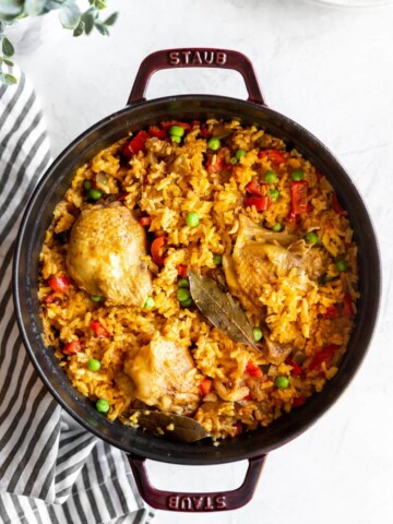 Staub dutch oven with cooked Cuban yellow rice with chicken (arroz con pollo)