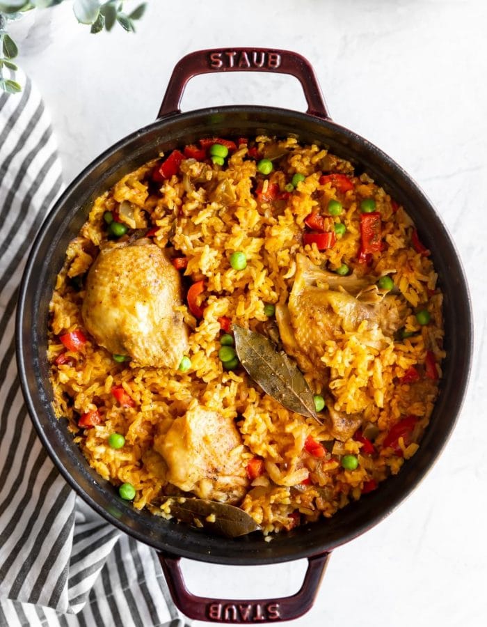 Staub dutch oven with cooked Cuban yellow rice with chicken (arroz con pollo)