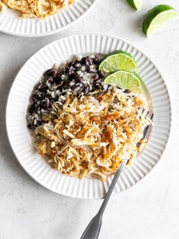 cuban shredded chicken with black beans and rice on a white plate