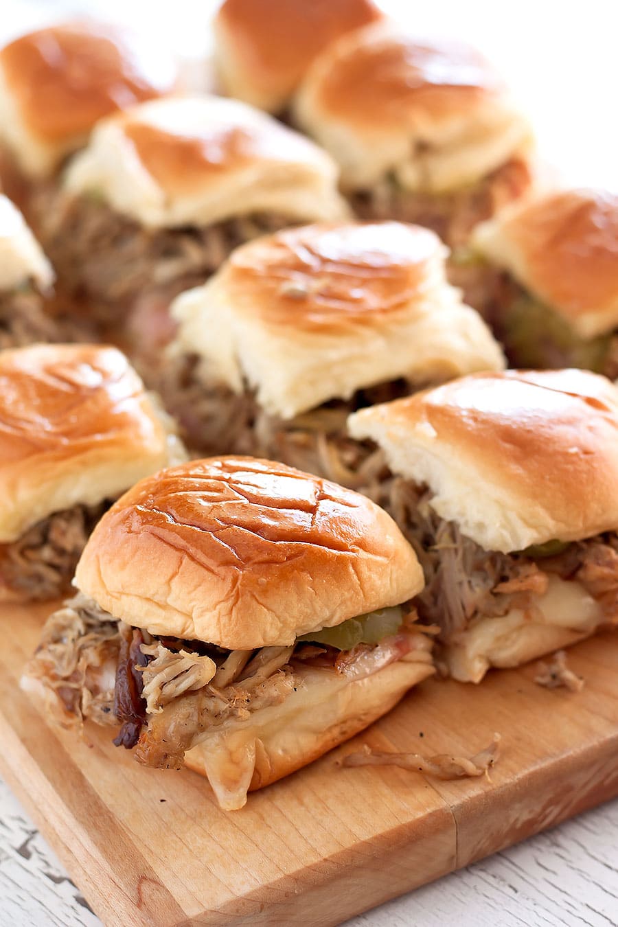 Cuban sliders with toasty sweet rolls and melty Swiss cheese, sweet ham, shredded Cuban roast pork, and Dijon mustard.