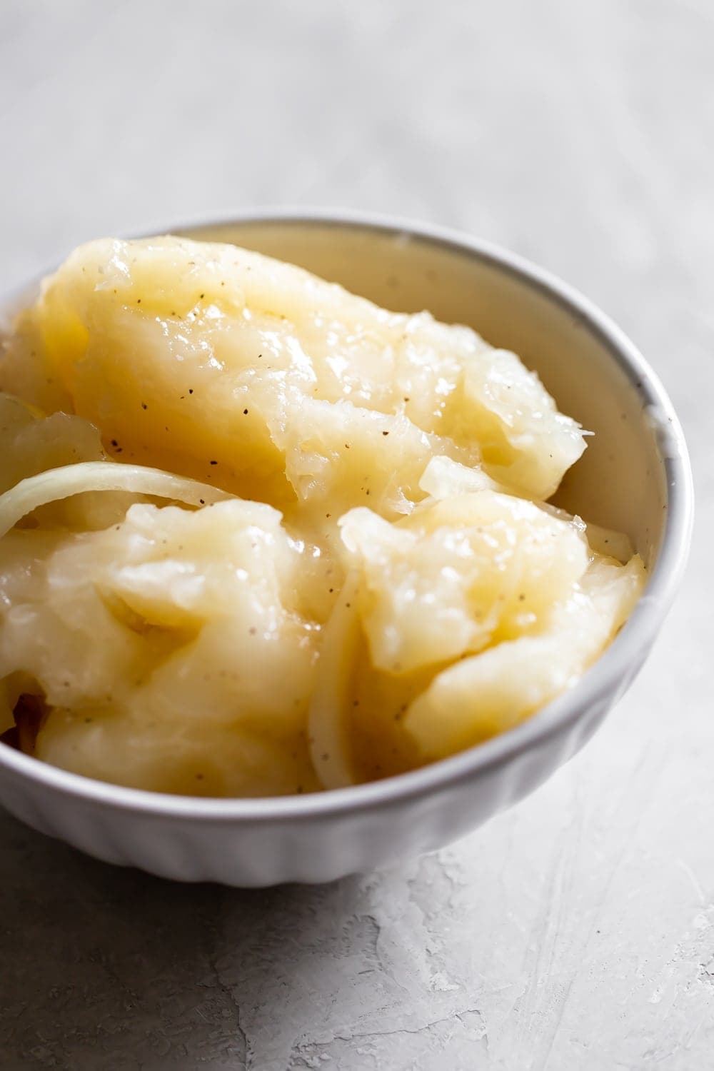 Cuban yuca with mojo sauce in a white bowl