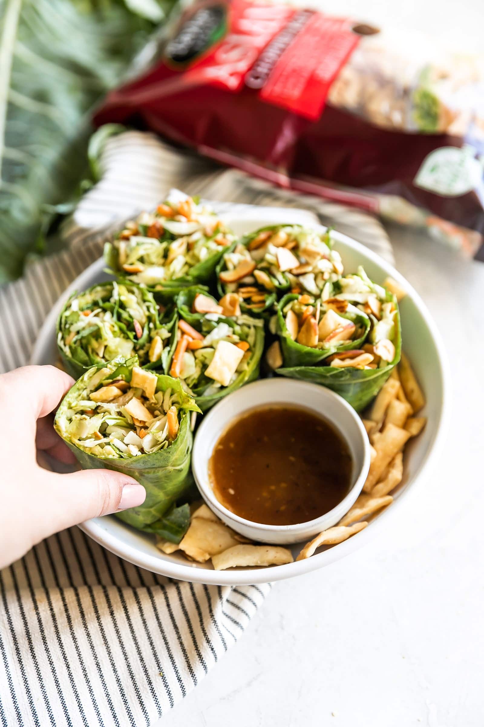 Simple collard green wraps made with avocado, savory green cabbage, carrots, celery, green onions, cilantro, toasted slivered almonds, crisp wontons, and sweet sesame ginger dressing!
