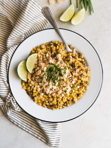 Easy Chipotle Mexican Street Corn. Fire roasted corn mixed with spicy chipotle mayo and mozzarella then topped with crushed pork rinds, crumbled cotija and chives.
