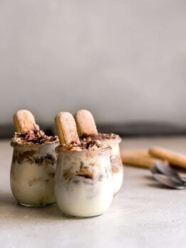 Three tiramisu cups with mascarpone mousse and espresso soaked ladyfingers