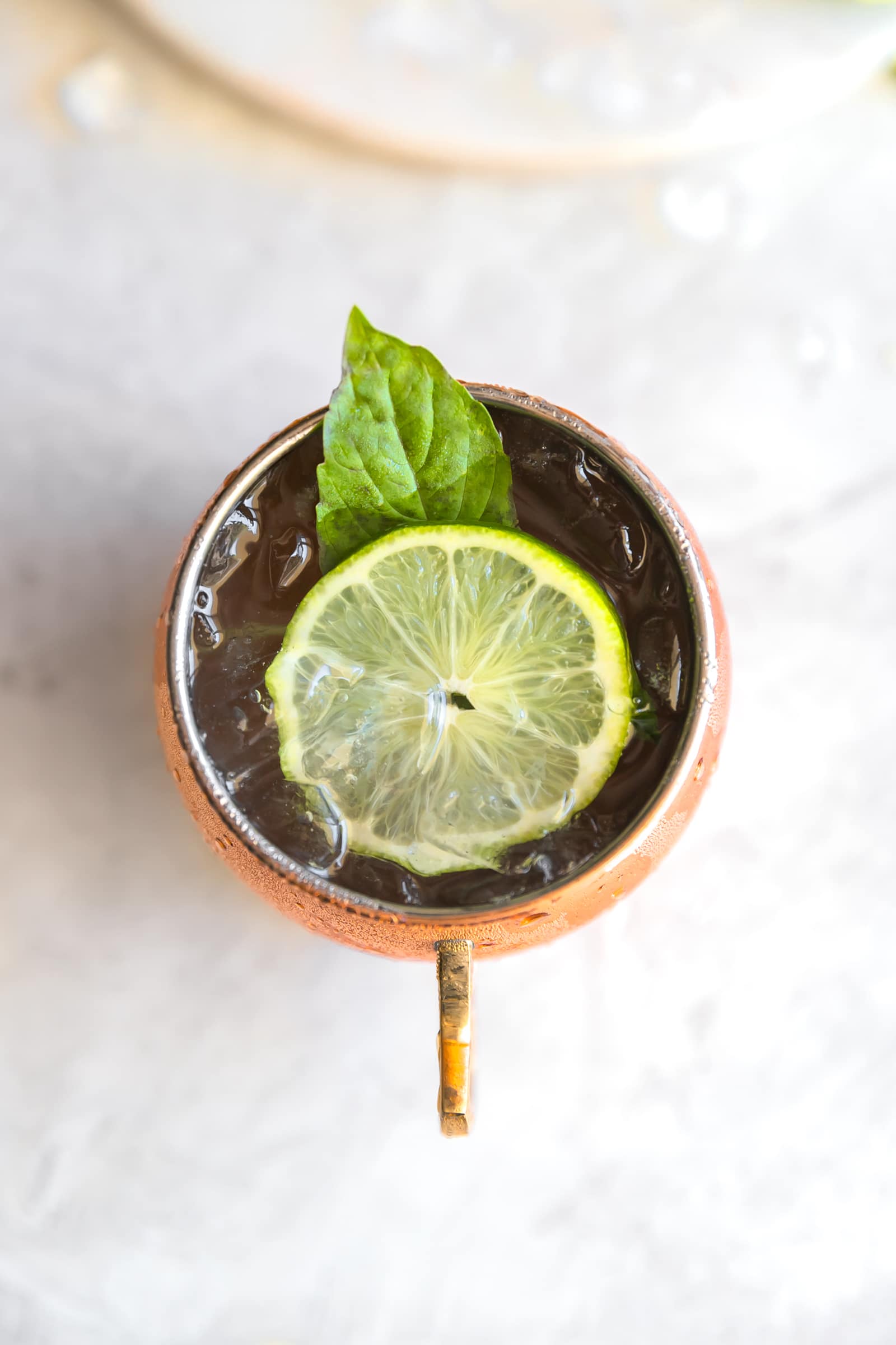 Guava Basil Moscow Mule. A twist to the traditional refreshing Vodka cocktail made with spicy ginger beer, guava nectar, fresh lime and sweet basil. Delicious drink for any time of year!