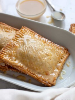 Super easy, semi-homemade guava and cream cheese pop tarts made using refrigerated pie crust then topped with a drizzle of condensed milk. The perfect combination of a Cuban treat on an American classic.