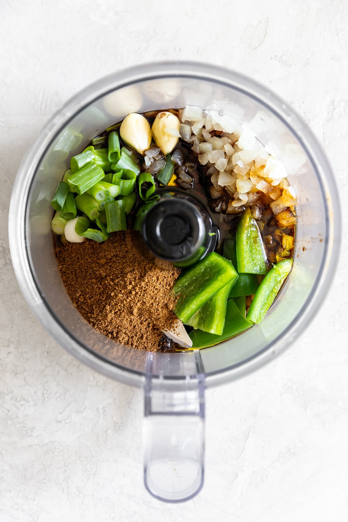 jerk seasoning, jalapenos, green onions, garlic, onions, soy sauce, and olive oil in the food processor