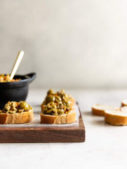 A simple yet irresistible appetizer made with tart, briny olives, capers, fresh garlic, pepper, and olive oil then served on toasted baguette slices brushed with olive oil.