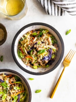 egg roll in a bowl cole slaw, ground pork, sesame oil in a bowl with a fork