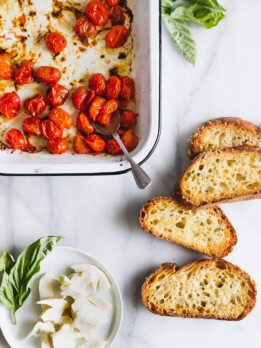Caprese salad on toast! Cherry tomatoes are roasted until bursting and lightly browned then served with fresh mozzarella on thick, olive-oil-toasted bread.