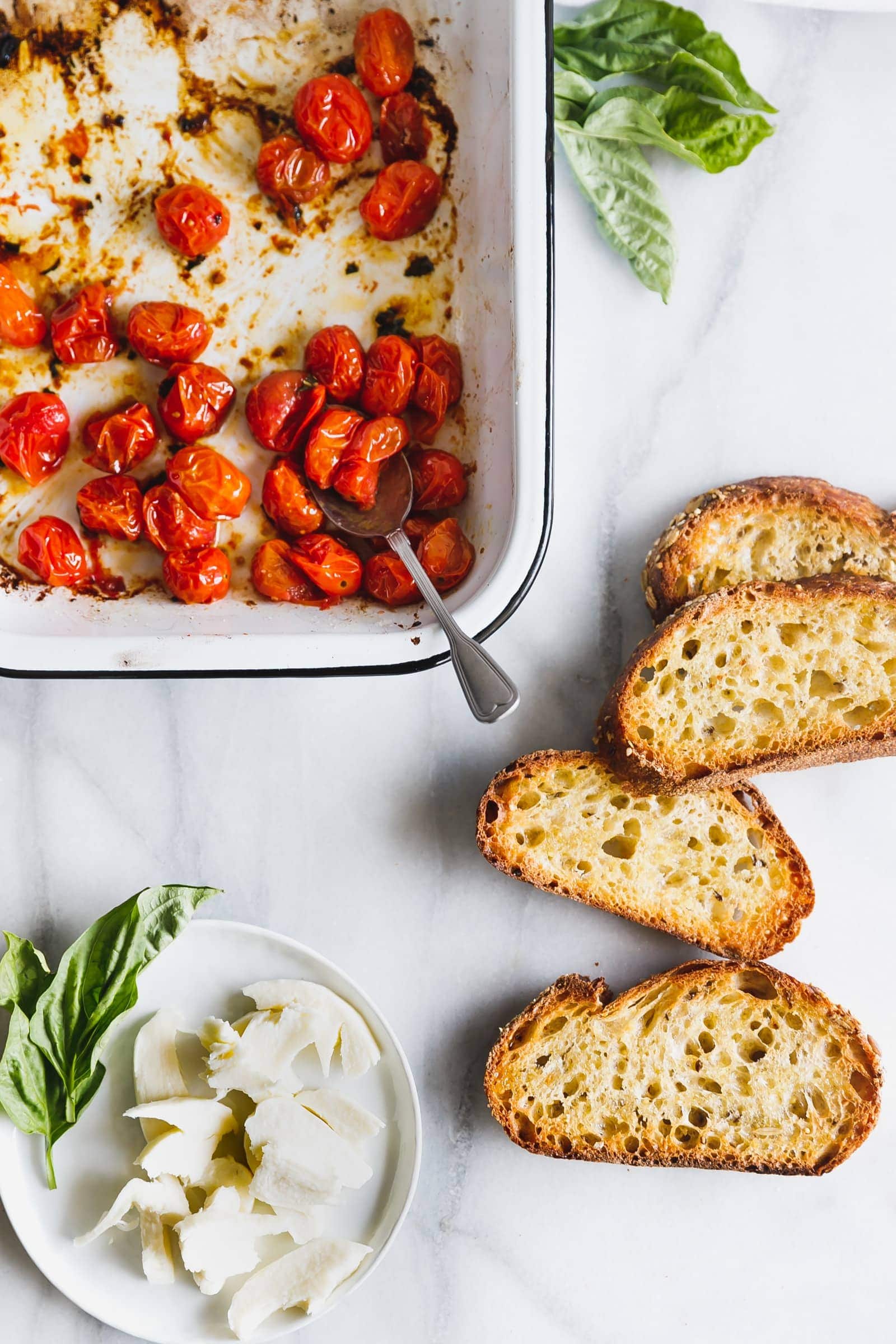 Caprese salad on toast! Cherry tomatoes are roasted until bursting and lightly browned then served with fresh mozzarella on thick, olive-oil-toasted bread.