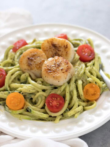 Zucchini noodles topped with a avocado sauce and seared scallops